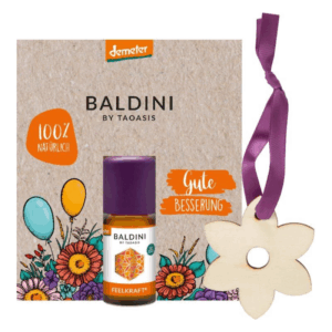 Verpackung mit ätherischem Öl von Baldini, Umgeben von bunten Blumen und der Aufschrift 'Gute Besserung'.