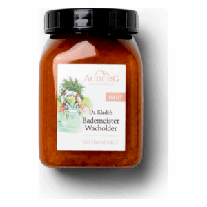 Ein Glasbehälter mit Deckel, gefüllt mit Badesalz, beschriftet als "Dr. Klade's Bademeister Wacholder".