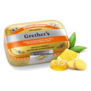 Dose mit Grether’s pastillen in Zitrone-Ingwer Geschmacksrichtung, mit frischen Ingwer- und Zitronenscheiben daneben.