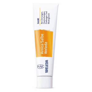Tube mit Weleda Arnica-Salbe, genutzt zur Linderung von Zerrungen und Blutergüssen, mit weißer und orangefarbener Verpackung.