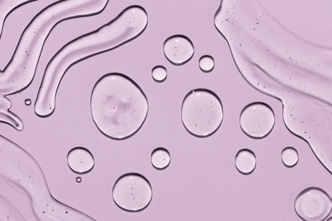 Transparente Wassertropfen auf einem helllila Hintergrund, mit fließenden Linien und Blasen.