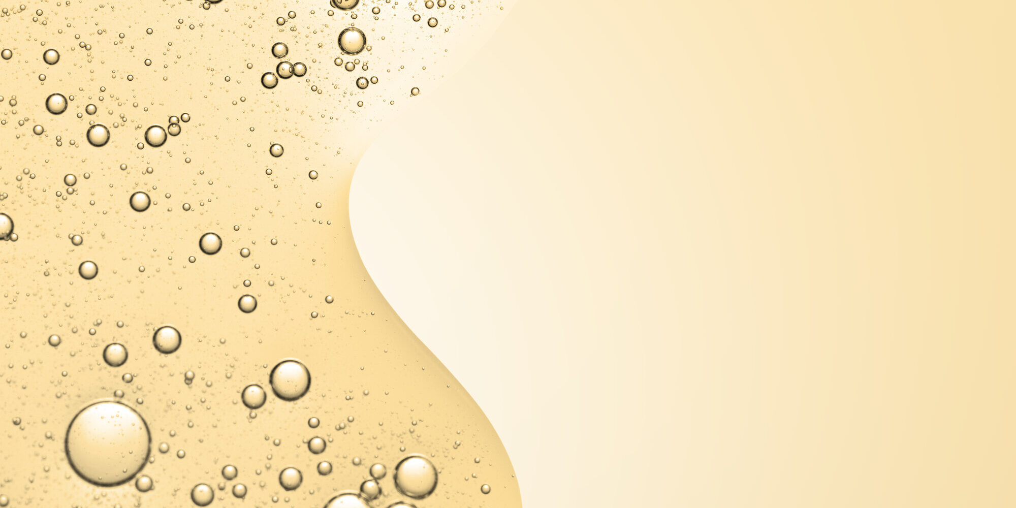 Goldfarbener Flüssigkeitshintergrund mit zahlreichen Blasen, die eine glatte, fließende Struktur bilden.
