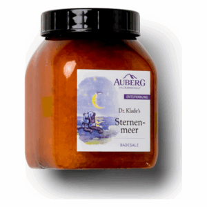 Glasbehälter mit orangefarbenem Badesalz, Label mit dem Titel 'Sternenmeer' von Dr. Klade, betont Entspannung.