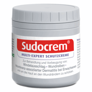 Runde, graue Dose mit Sudocrem Schutzcreme und rotem Schriftzug, behandelt Hautprobleme.