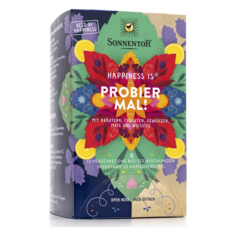 Bunte Teepackung von Sonnentor mit dem Schriftzug 'HAPPINESS IS PROBIER MAL!' und verschiedenen Blumenmustern.