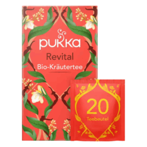 Verpackung von Pukka Revital Bio-Kräutertee in roter Box mit Pflanzenmotiven und einem Sichtfenster für Teebeutel.