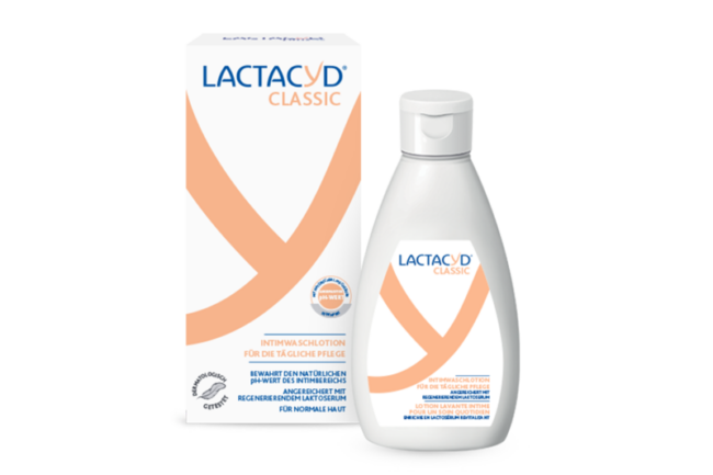 Lactacyd Classic Intimwaschlotion in einem weißen Flacon neben der Verpackung mit orangefarbenen Akzenten und Beschreibung oben.