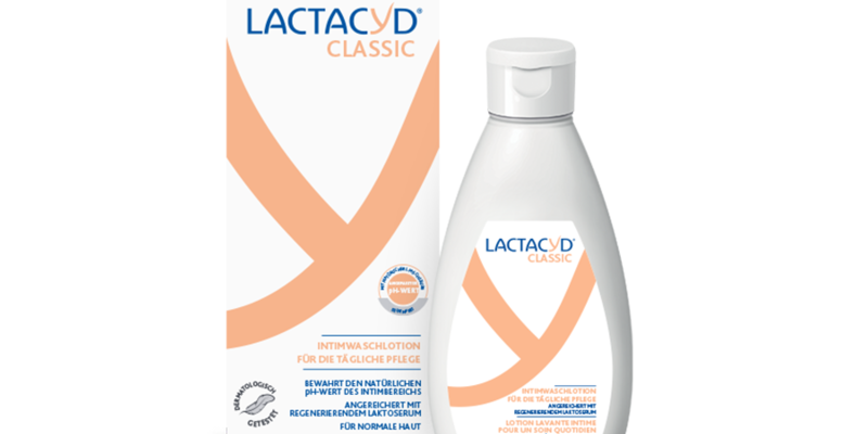 Lactacyd.png Lactacyd Classic Intimwaschlotion in einem weißen Flacon neben der Verpackung mit orangefarbenen Akzenten und Beschreibung oben.